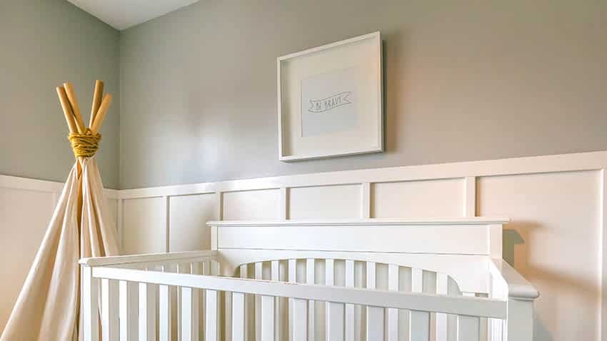 Nursery room with wall panels and white crib