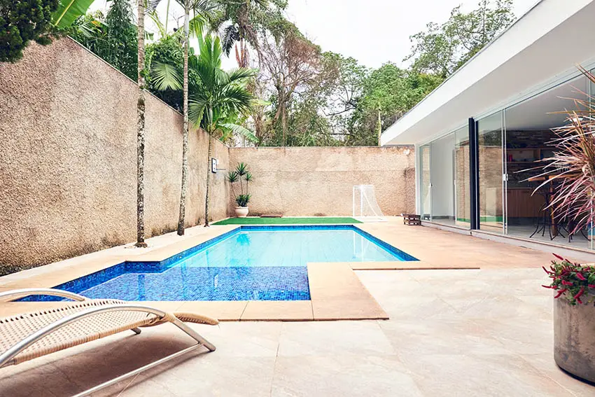 Backyard swimming pool with limestone deck patio