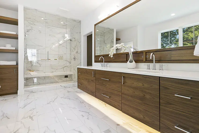 Bathroomwith brown drawers, open shelving with folded towers and wide mirror
