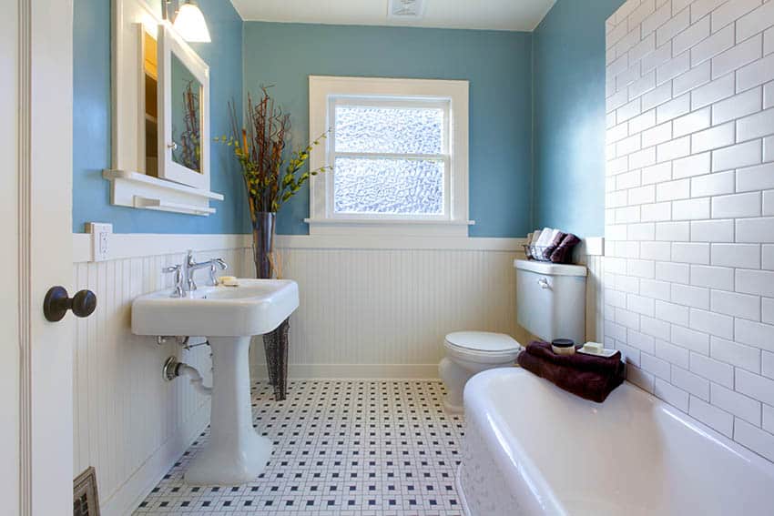 Bathroom with subway tile backsplash, blue walls and pedestal sink