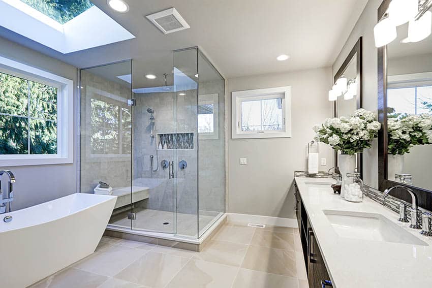 Bathroom with beige porcelain tile shower dark wood vanity arctic white quartz countertop freestanding tub