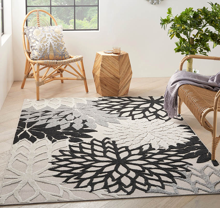 Wicker chairs, side table and black and white rug with floral design