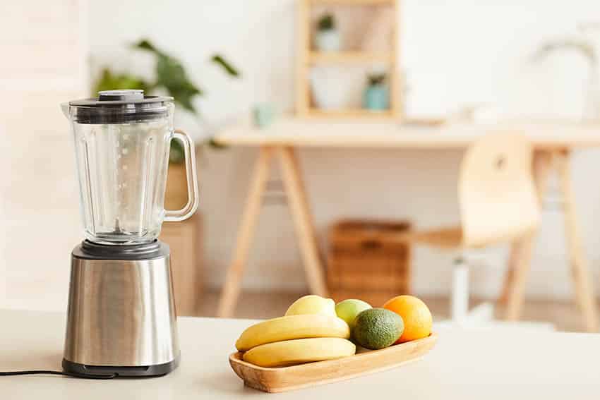 Blender and a small tray of fruit on countertop