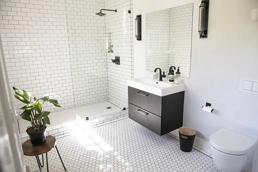 White bathroom with penny tile flooring and subway wall tiles