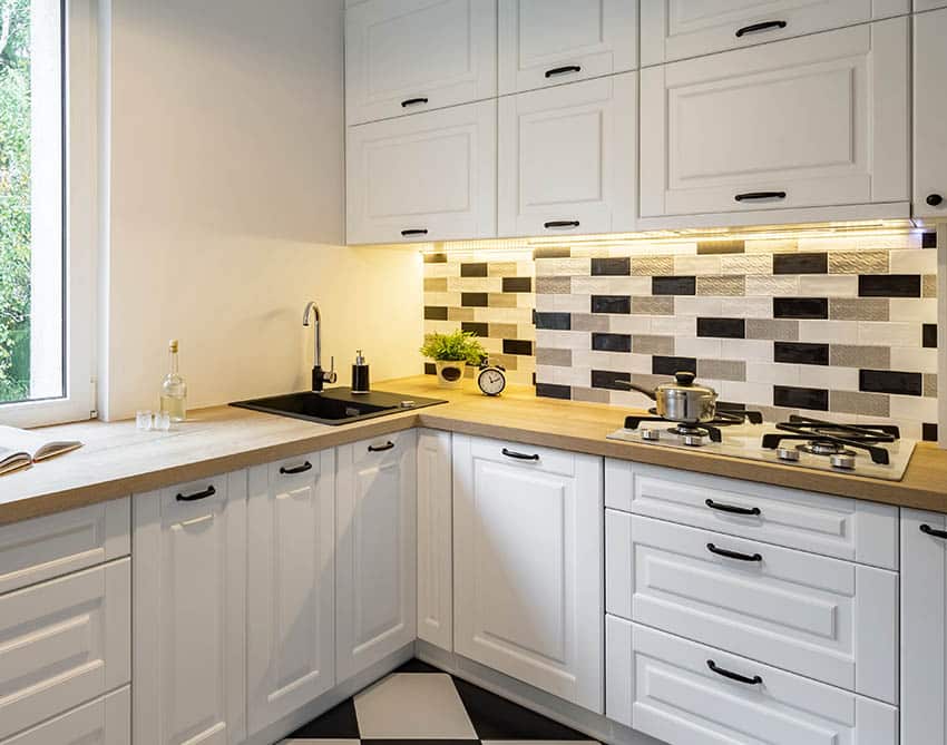 Corner kitchen with black silgranit sink white cabinets butcher block countertops