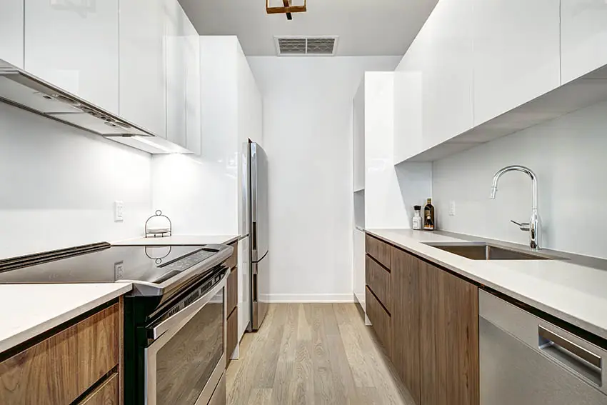 Galley kitchen with white corian countertops wood veneer cabinets