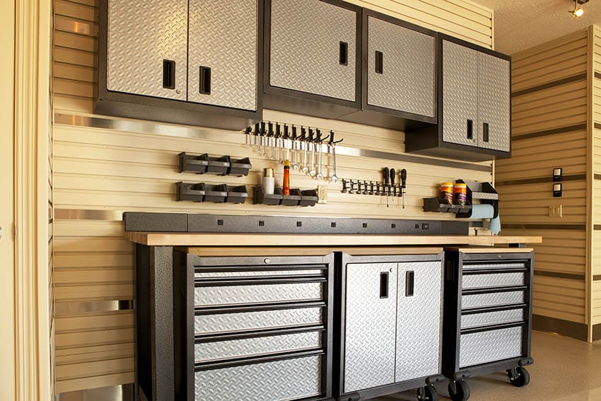 Garage with well organized rolling toolbox and wall mounted cabinets with metal doors