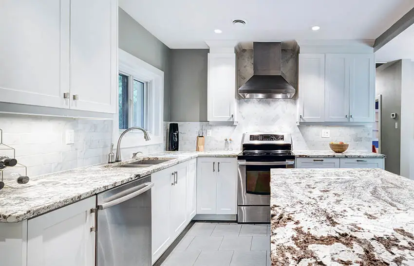 L shaped kitchen with granite countertops island and white cabinets