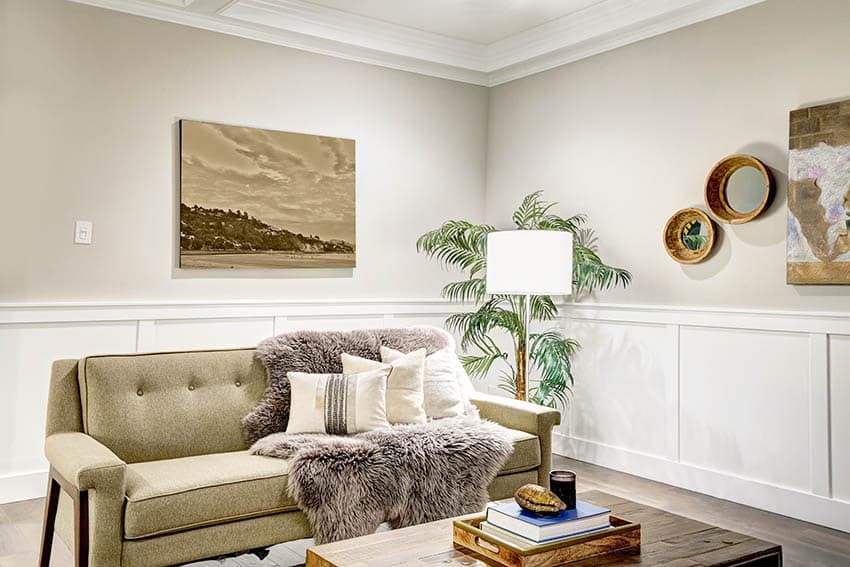 Room with wall molding, being loveseat, white floor lamp and wall decor