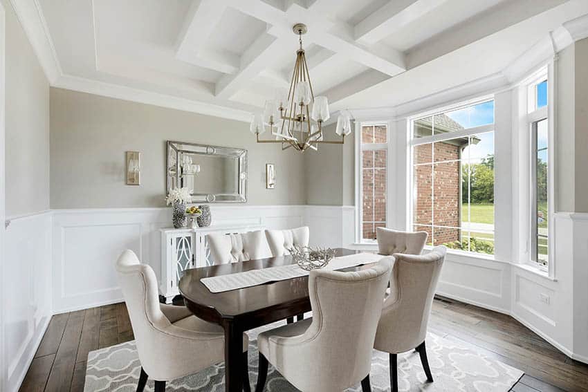 Dining room with bay windows, chandelier and wingback chairs