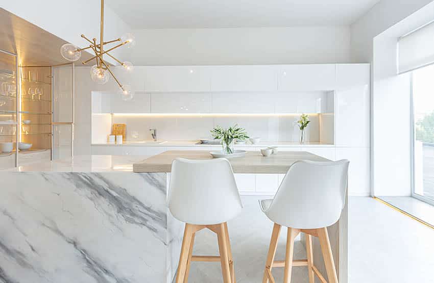 Luxury kitchen with high gloss lacquer cabinets, quartz countertops, and modern gold chandelier