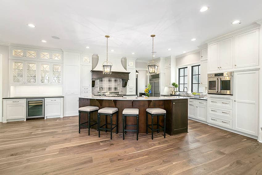 Kitchen with wood look porcelain tile flooring, white cabinets and large wood island bar 