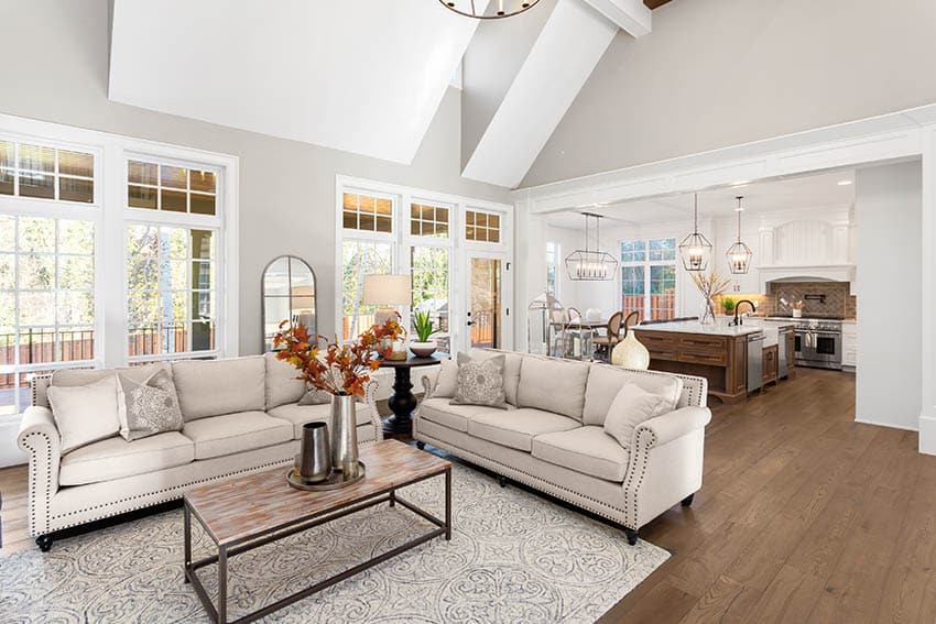 White room with cream colored polyester rug and cream sofa and windows