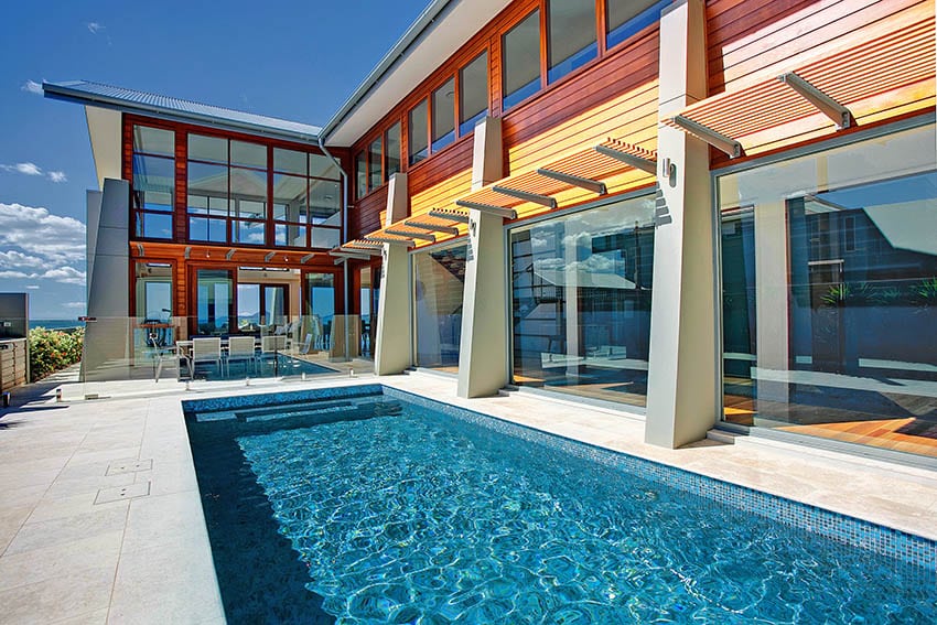 Modern home with large travertine pool deck