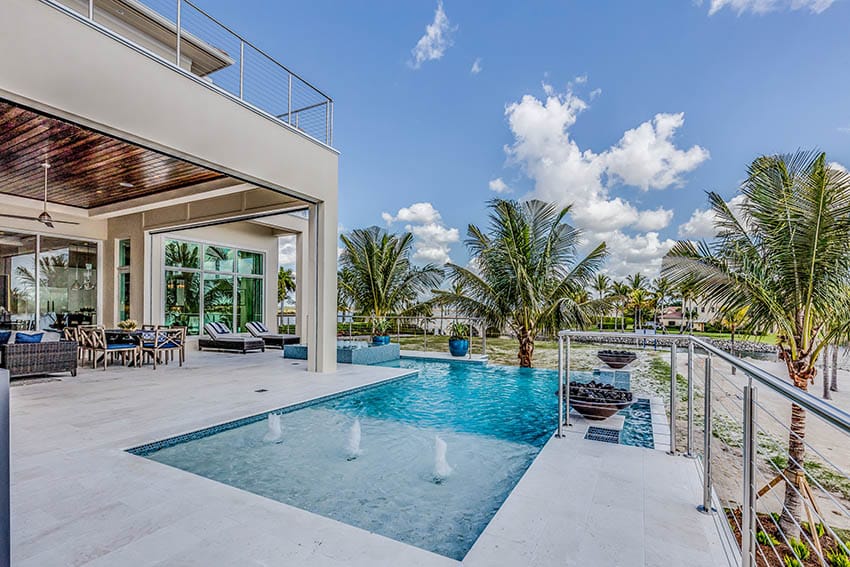 Modern infinity edge pool with white travertine deck