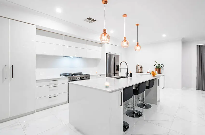 Modern kitchen with white high gloss cabinets large island with white quartz marble look porcelain tile flooring