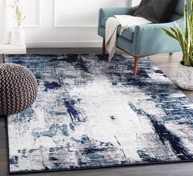 Blue polyester area rug with grey ottoman 