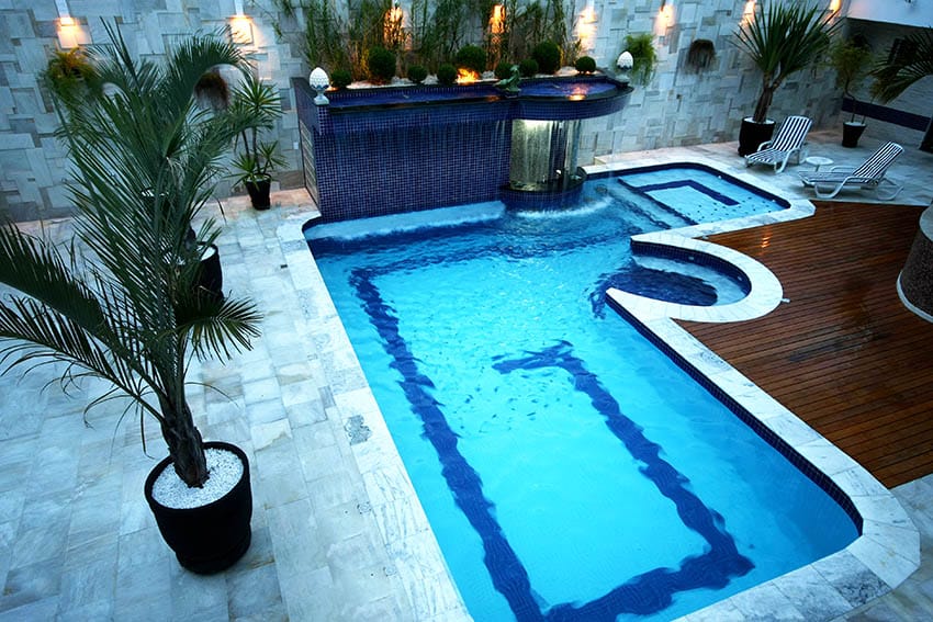 Modern swimming pool with marble deck and wood deck