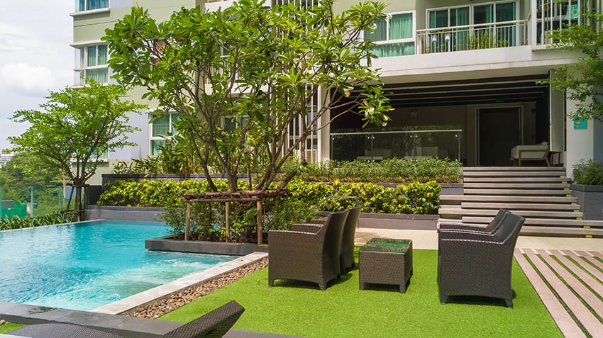 Pool with grass and outdoor furniture