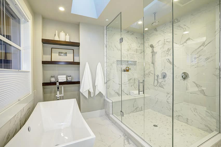 Bathroom with marble flooring and seamless glass shower