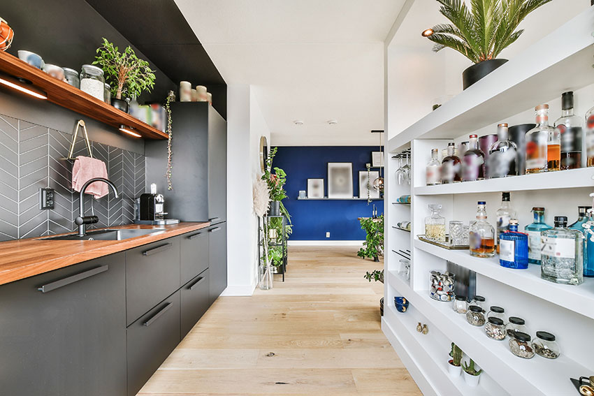 Modern kitchen with wooden countertop black cabinets white pantry