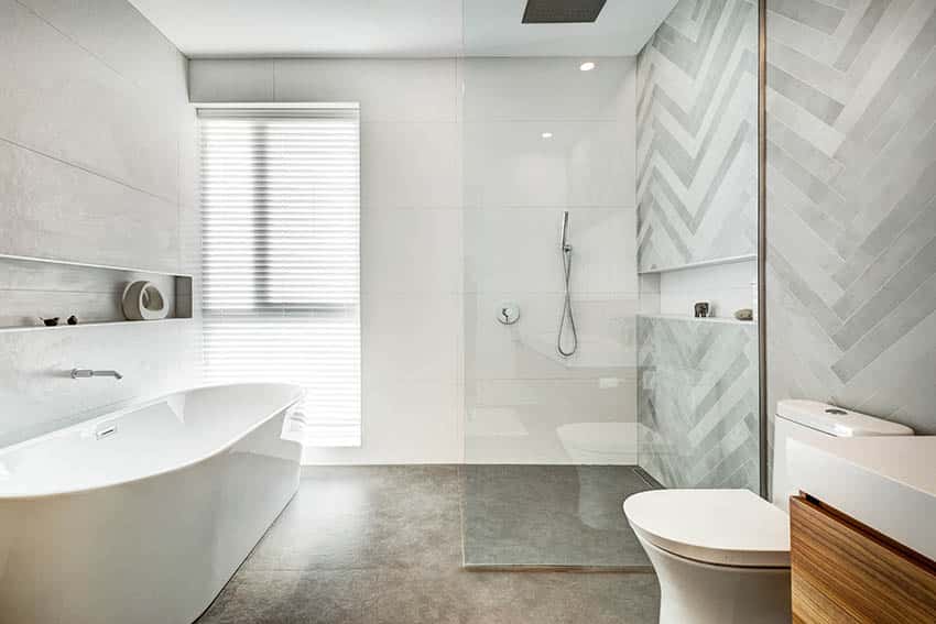 Bathroom wet room with concrete shower floor and large freestanding tub