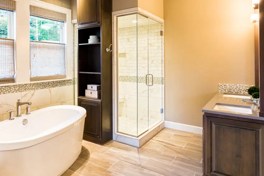 Bathroom with wood flooring glass door and bathtub