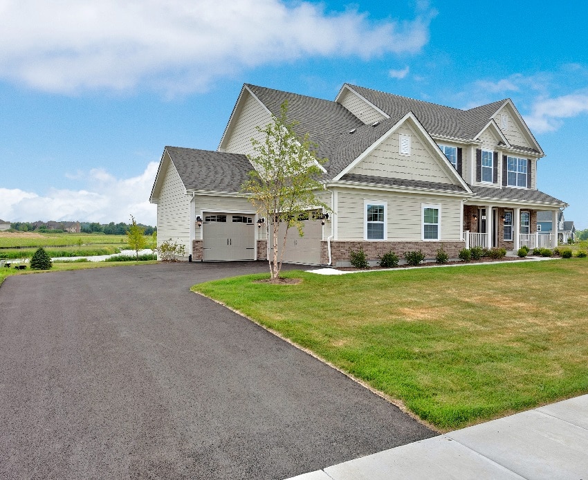 Beautiful house with asphalt driveway leading to three car garage