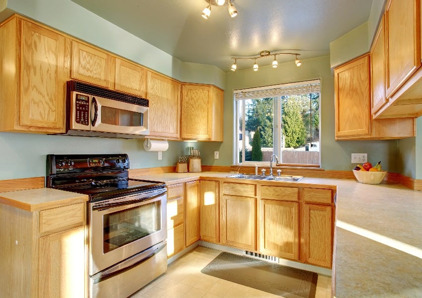 beautiful traditional kitchen with hardwood floor oak cabinetry light green wall stove and oven