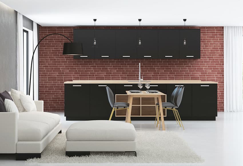  Gabinete de cocina negro con pared de ladrillo rojo