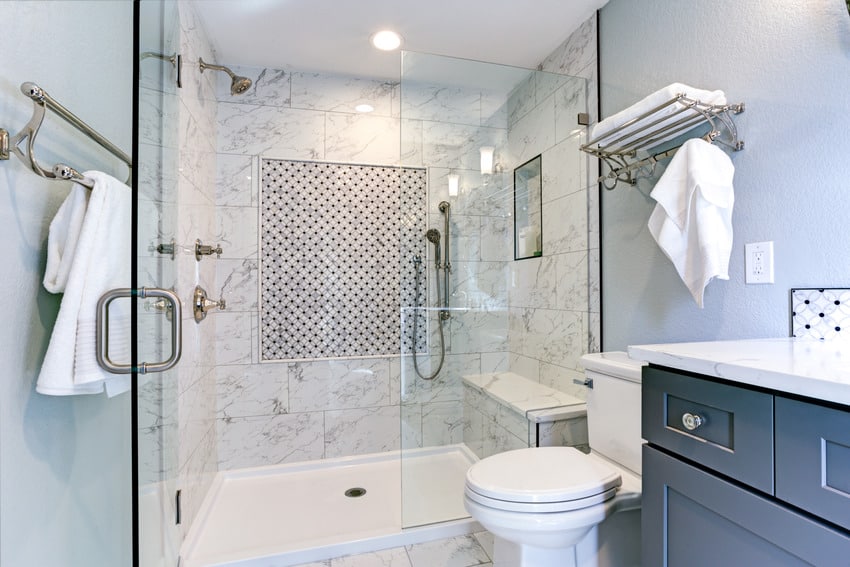 Bathroom design with Carrara marble shower, bench, shower head, glass door, and toilet