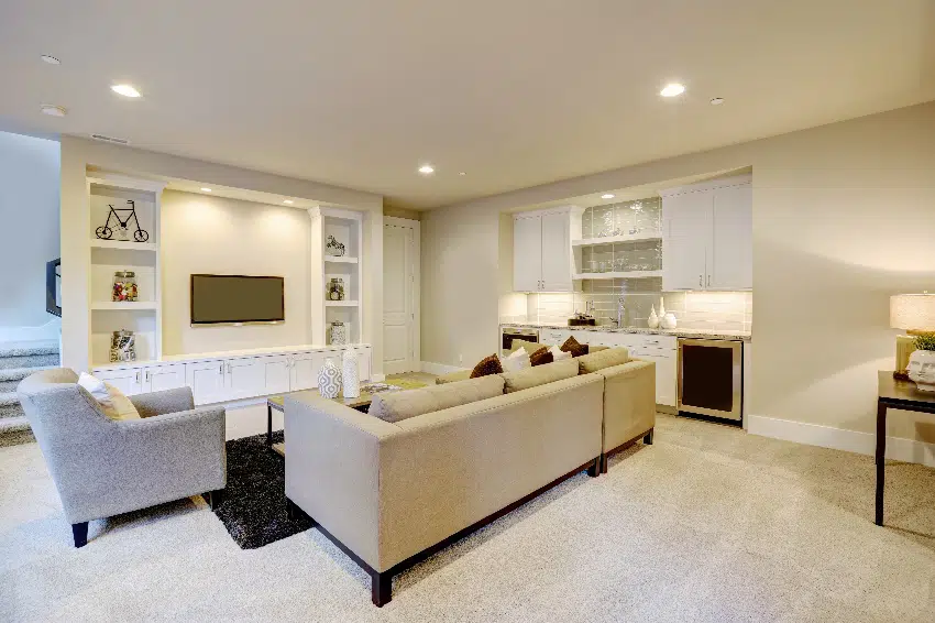 chic basement features a light brown sectional facing white wall with built in tv and cabinets