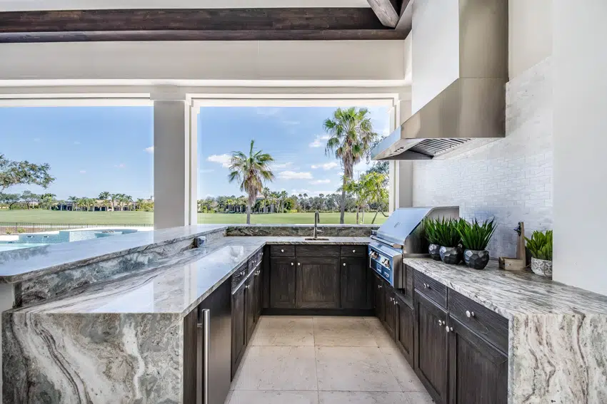Classy looking outdoor kitchen with grill hood cabinets countertop and island
