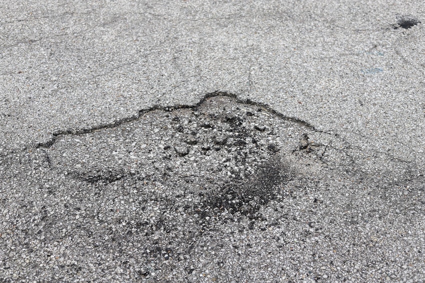 Close-up image of cracked asphalt on a street