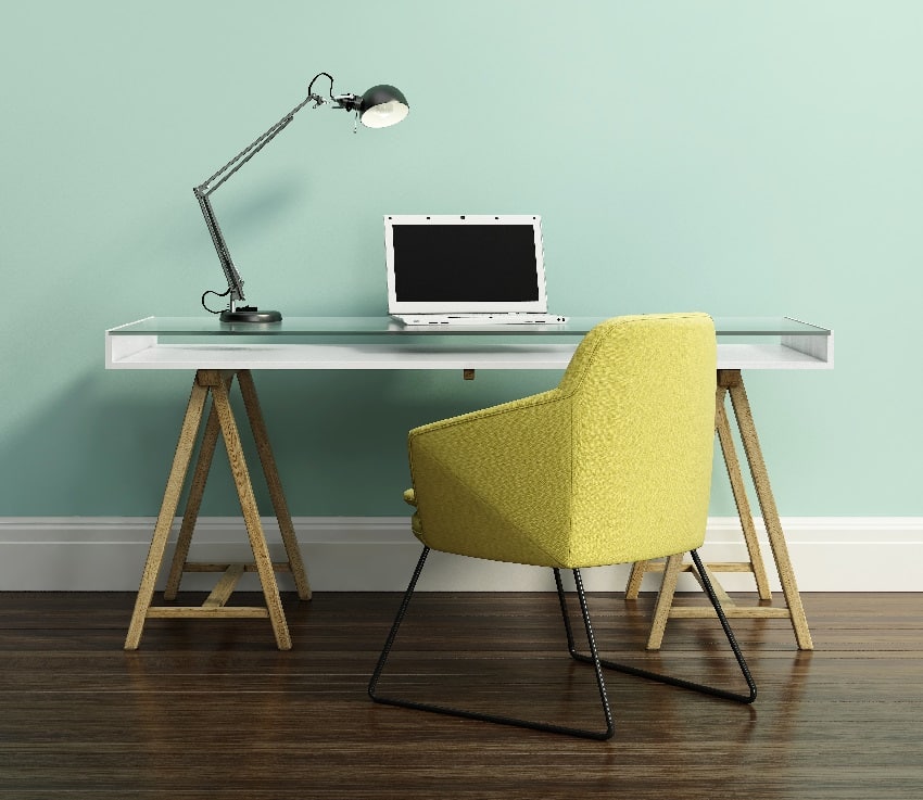 contemporary home office with yellow armchair desk laptop and lamp on it