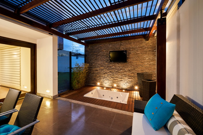 Contemporary patio with wood pergola, bathtub and wall mounted television