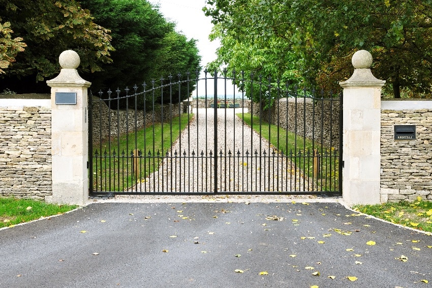 Country estate gates with asphalt and gravel driveway