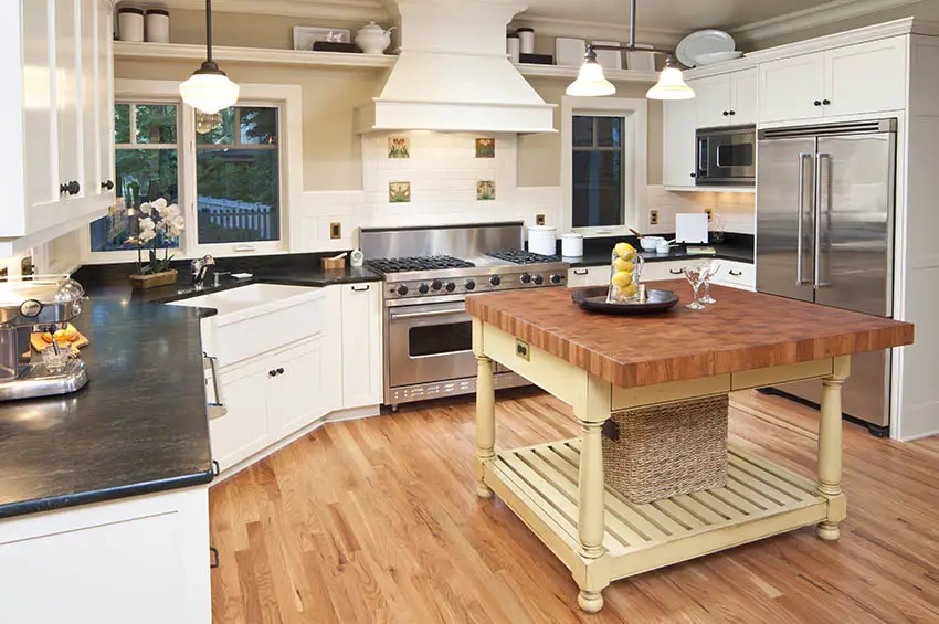 Country kitchen with end grain butcher block island white cabinets black soapstone countertops