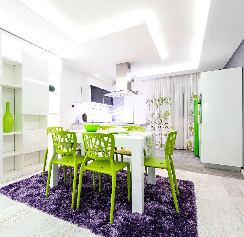 Dining area with green chairs white table and purple mat
