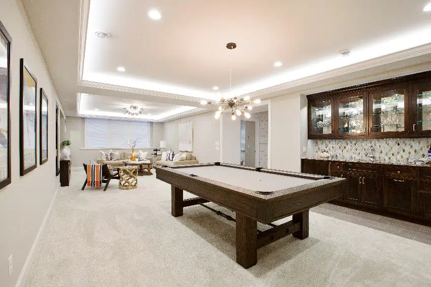 elegant basement with white wall paint billiards table with kitchenette nearby