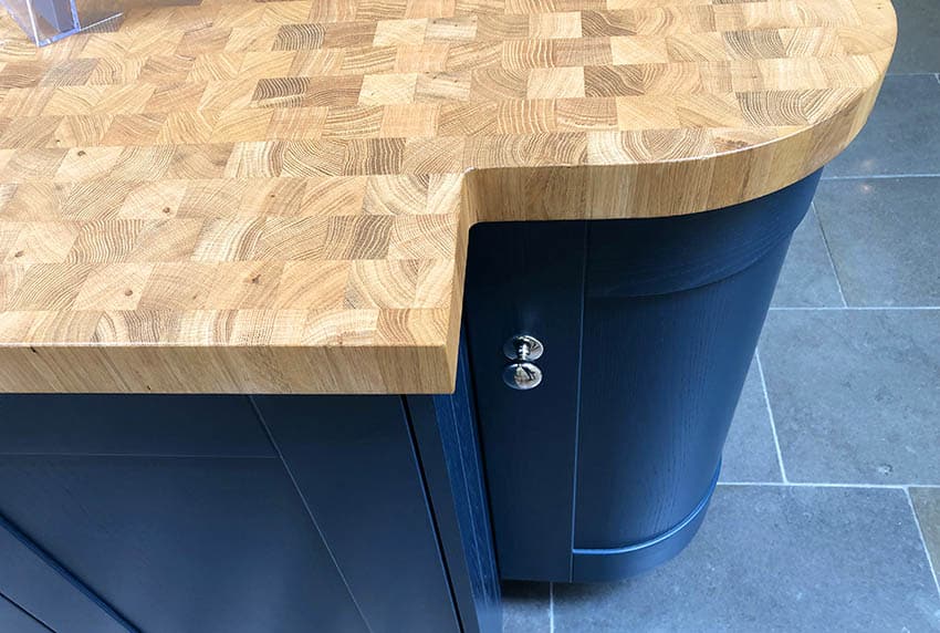 End grain butcher block walnut wood kitchen countertop on blue cabinets