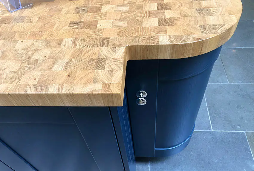 End grain butcher block walnut wood kitchen countertop on blue cabinets