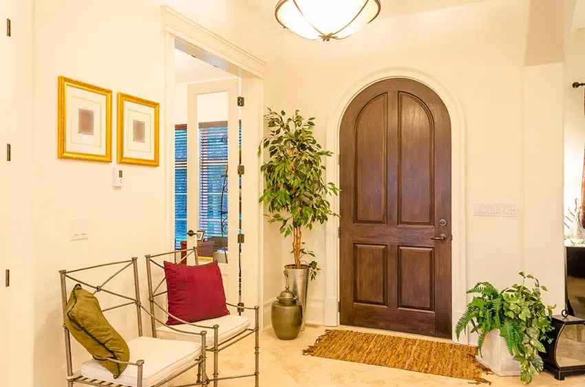 Arched entryway, rug, beige walls and wall art