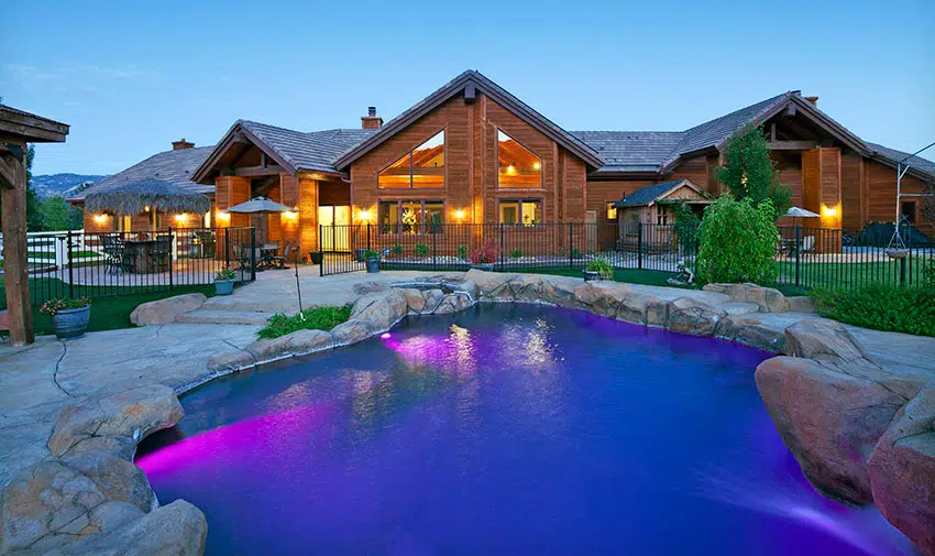 Exterior home with mood lighting and pool