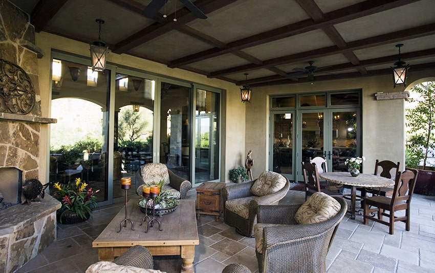 Folding patio door with stone fireplace and outdoor furniture