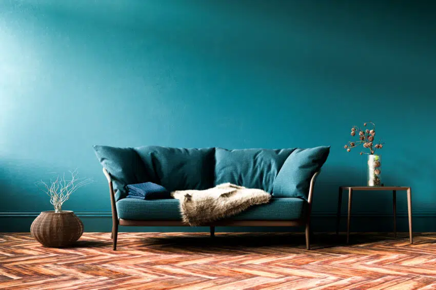 Green fabric sofa in front of wall and wood floor