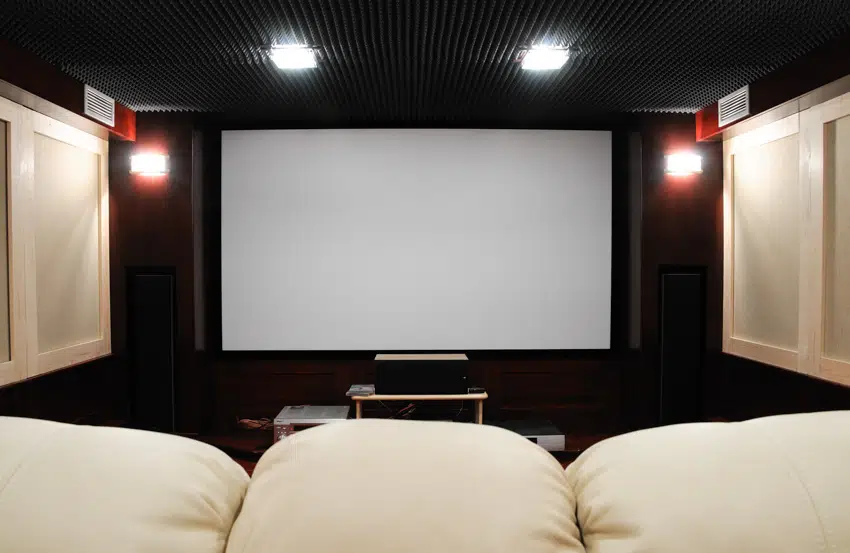 Home theater with black ceiling and white sofa style chairs