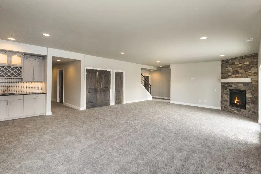 huge open basement room in cream white wall paint and carpet flooring