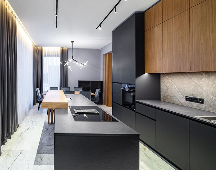 Kitchen with black cabinets, dark curtains, hanging lights, dining table and island