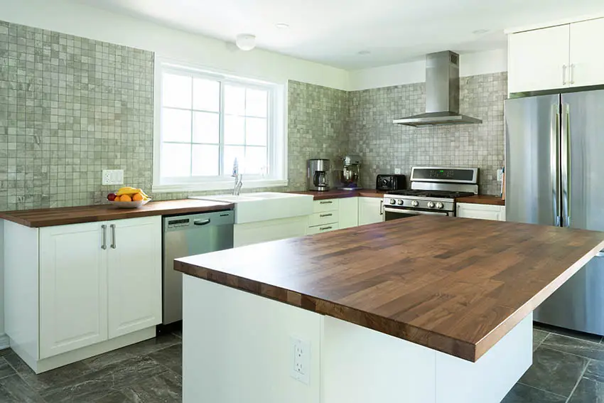 Kitchen with butcher block wood countertops white cabinets mosaic tile full wall backsplash